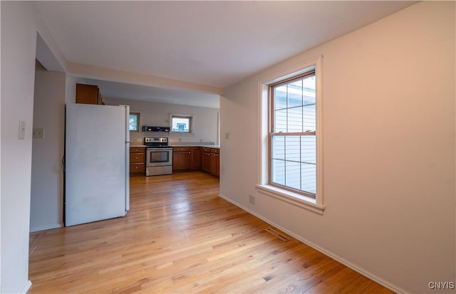 2795 State Route 12b, Marshall, NY 13328 - kitchen featuring stainless steel electric stove, freestanding refrigerator, light wood-style flooring, and baseboards