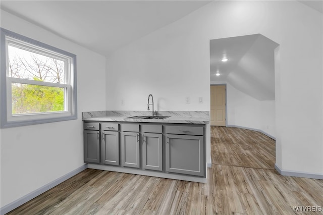 65 Kingsley St, Buffalo, NY 14208 - kitchen with gray cabinetry, a sink, lofted ceiling, light wood-style flooring, and baseboards