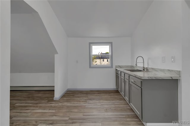 65 Kingsley St, Buffalo, NY 14208 - kitchen with a baseboard heating unit, a sink, gray cabinetry, light countertops, and light wood-style floors