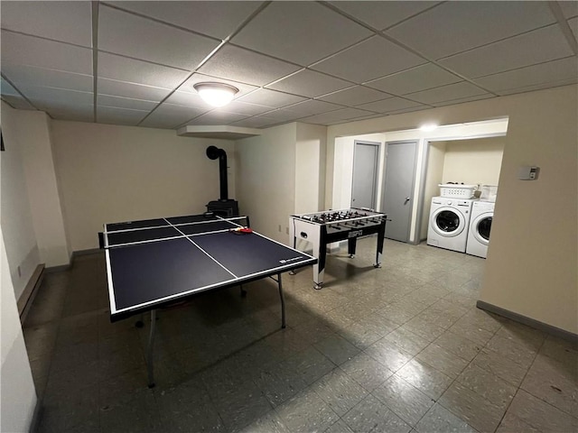 200 Torsten Ln, Davenport, NY 13750 - playroom with washing machine and dryer, baseboards, a drop ceiling, a wood stove, and tile patterned floors