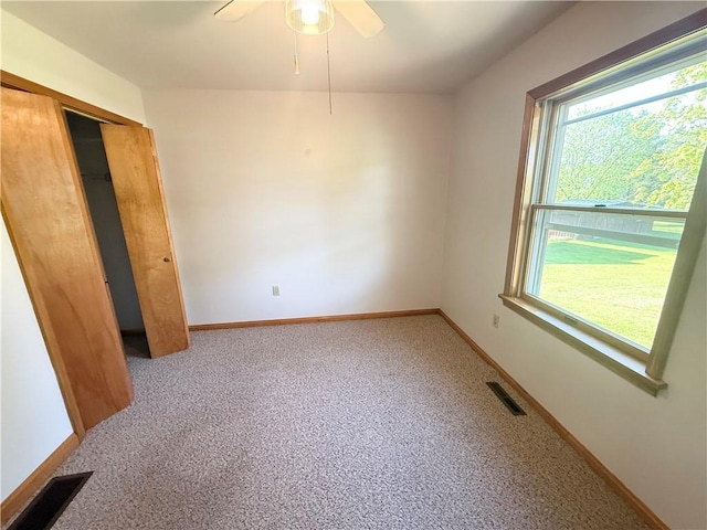 unfurnished bedroom featuring multiple windows, baseboards, a closet, and a ceiling fan