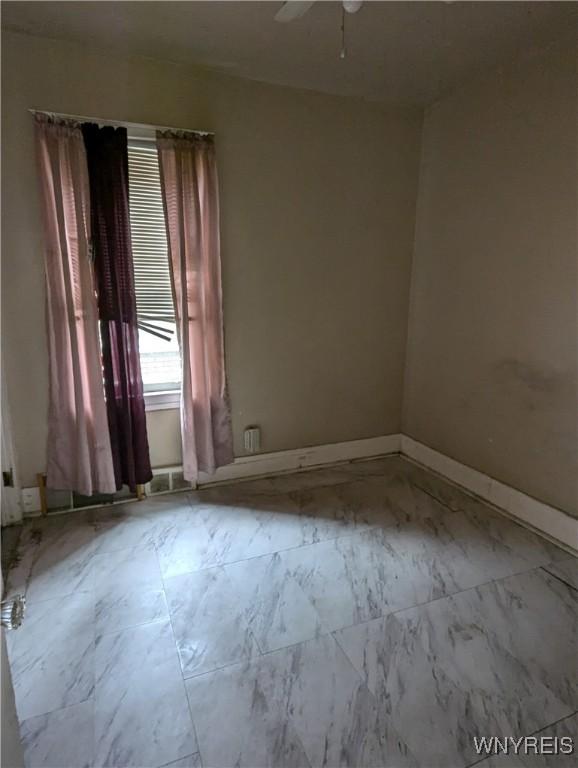 1706 Niagara St, Niagara Falls, NY 14303 - unfurnished room with ceiling fan, marble look tile flooring, and baseboards