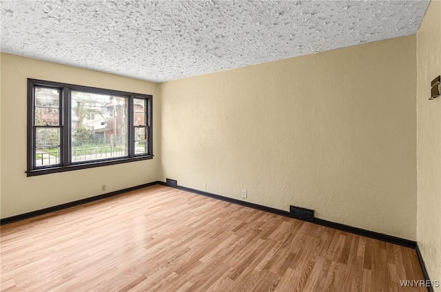414 18th St, Niagara Falls, NY 14303 - spare room featuring light wood-style flooring, a textured wall, and baseboards