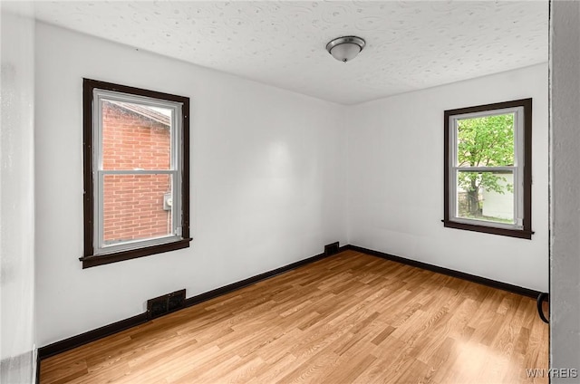 414 18th St, Niagara Falls, NY 14303 - spare room featuring light wood-style flooring, baseboards, and a textured ceiling