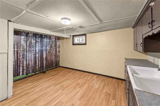 414 18th St, Niagara Falls, NY 14303 - basement featuring a sink, light wood finished floors, baseboards, and a textured ceiling