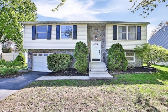 7025 Academy Ln, Lockport-Town, NY 14094 - raised ranch featuring stone siding, asphalt driveway, a garage, and a front lawn