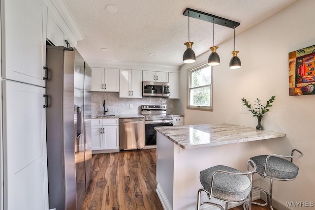 7025 Academy Ln, Lockport-Town, NY 14094 - kitchen with appliances with stainless steel finishes, a sink, white cabinets, a peninsula, and a textured ceiling