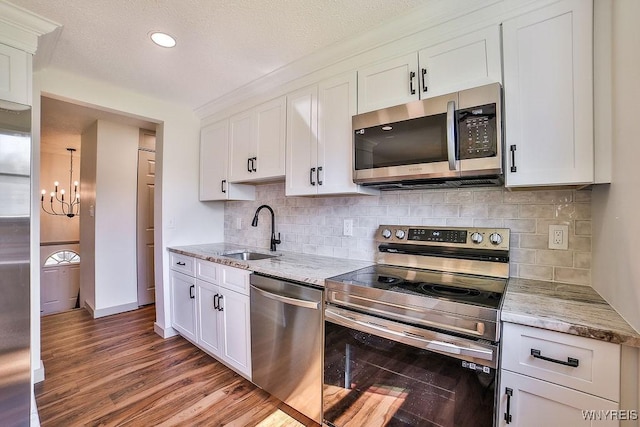 7025 Academy Ln, Lockport-Town, NY 14094 - kitchen featuring stainless steel appliances, a sink, wood finished floors, a chandelier, and light stone countertops