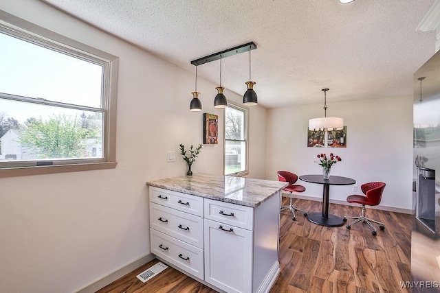 7025 Academy Ln, Lockport-Town, NY 14094 - kitchen featuring a textured ceiling, a peninsula, white cabinets, plenty of natural light, and dark wood-style flooring
