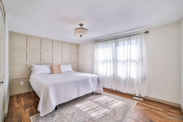 7025 Academy Ln, Lockport-Town, NY 14094 - bedroom featuring a textured ceiling, wood finished floors, and baseboards