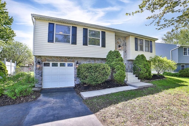 7025 Academy Ln, Lockport-Town, NY 14094 - raised ranch with stone siding, asphalt driveway, an attached garage, and fence