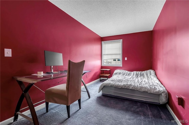 carpeted bedroom featuring a textured ceiling, lofted ceiling, a desk, and baseboards