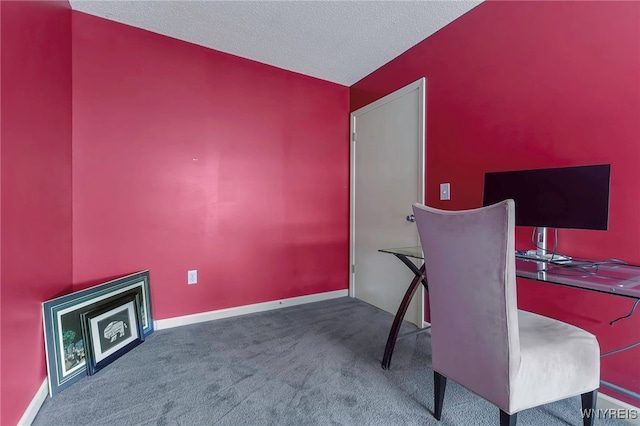 carpeted home office featuring a textured ceiling