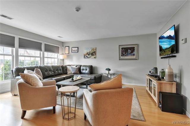 living room with light wood finished floors, healthy amount of natural light, and baseboards