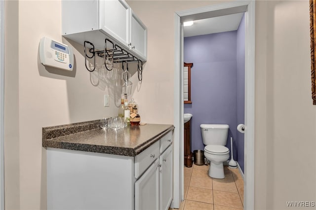 half bathroom with tile patterned floors, toilet, and vanity