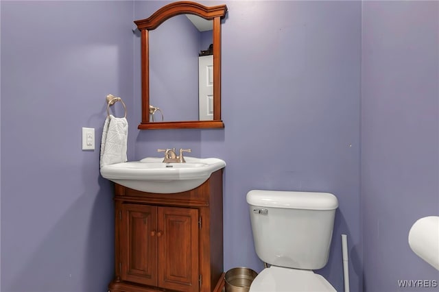 half bath featuring toilet and vanity