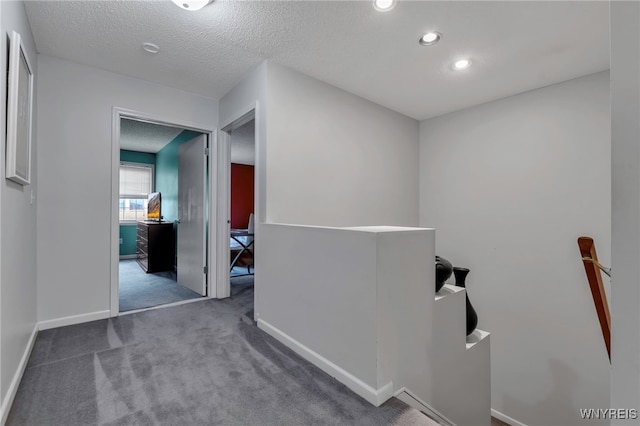 hallway featuring an upstairs landing, carpet flooring, baseboards, recessed lighting, and a textured ceiling