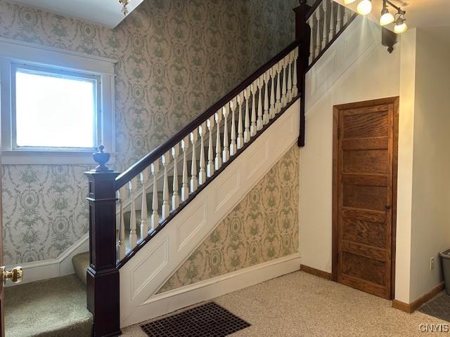 stairway featuring carpet floors and baseboards