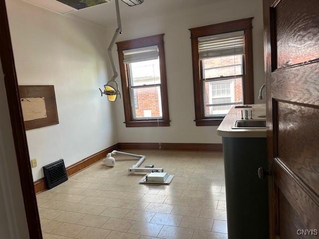 unfurnished room with a sink and baseboards