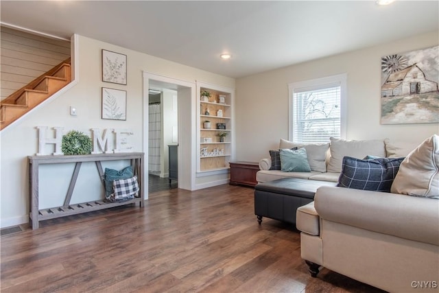 30622 Vanalstyne Rd, Clayton, NY 13622 - living room with dark wood-style floors, built in shelves, recessed lighting, stairs, and baseboards