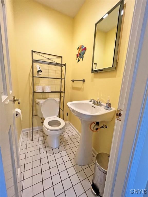 179 E Lake Rd, Deruyter, NY 13052 - bathroom featuring tile patterned flooring, toilet, baseboards, and a sink