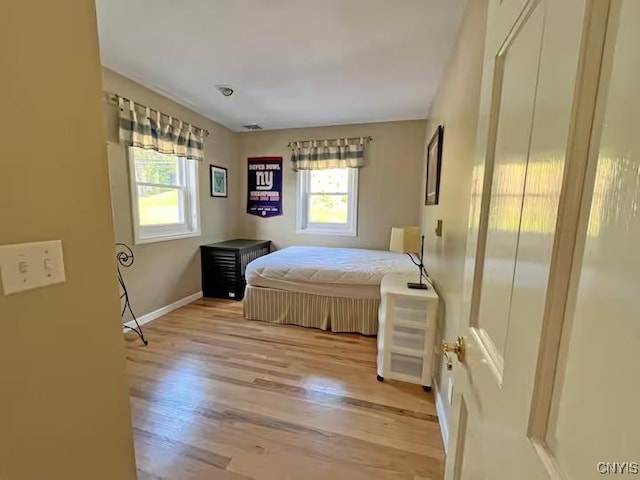 179 E Lake Rd, Deruyter, NY 13052 - bedroom with multiple windows, light wood-type flooring, and baseboards