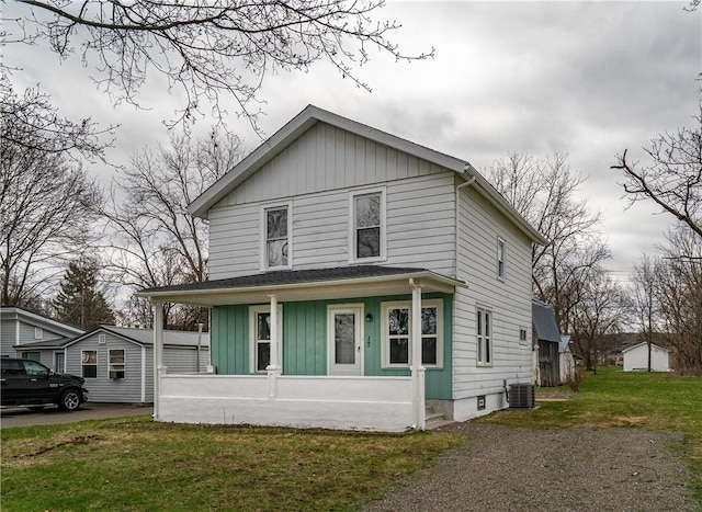 american foursquare style home featuring a porch, board and batten siding, a front lawn, and cooling unit
