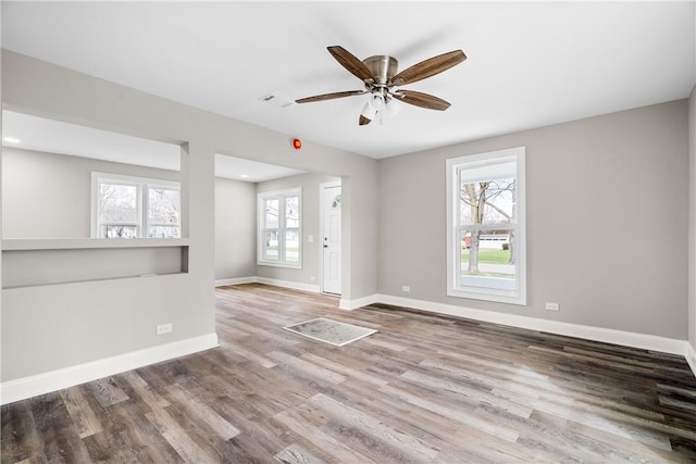 spare room featuring wood finished floors, baseboards, and a ceiling fan