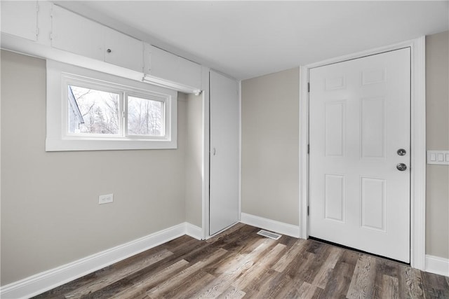 unfurnished bedroom with dark wood-style floors and baseboards