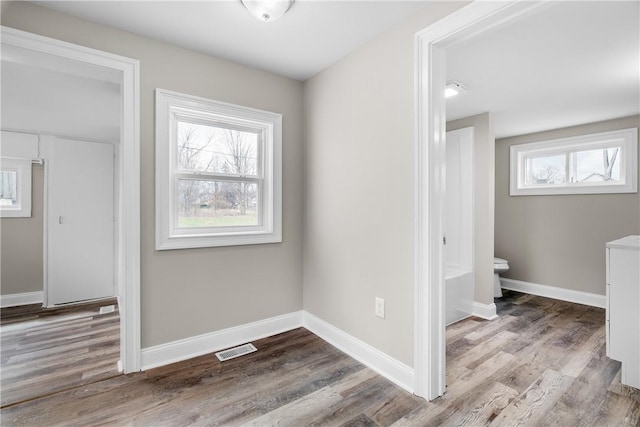 hallway featuring wood finished floors and baseboards