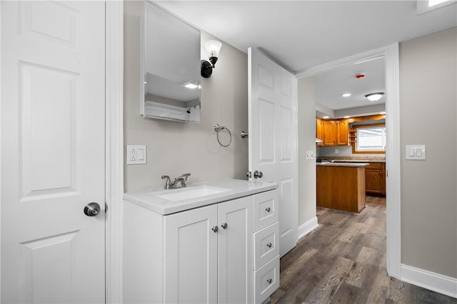 bathroom with wood finished floors, vanity, and baseboards