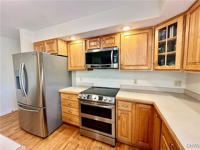 kitchen featuring appliances with stainless steel finishes, light countertops, and light wood-type flooring