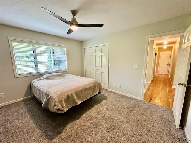 carpeted bedroom with a closet, baseboards, and ceiling fan