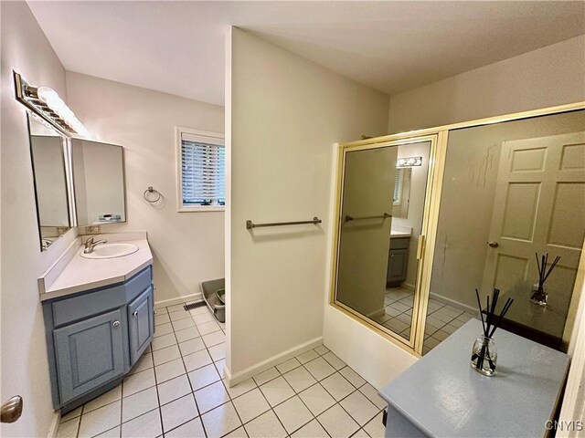 bathroom with a shower with shower door, tile patterned flooring, vanity, and baseboards