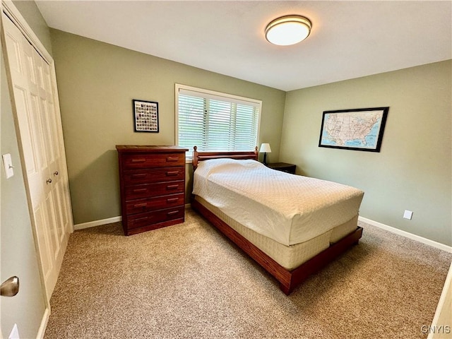 bedroom with light colored carpet, baseboards, and a closet