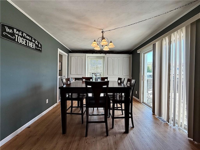 181 Dwight Ave, Corning-City, NY 14830 - dining room with a chandelier, plenty of natural light, wood finished floors, baseboards, and ornamental molding