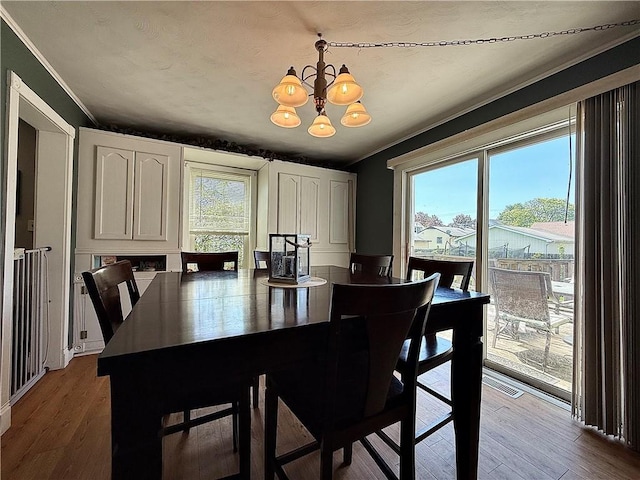 181 Dwight Ave, Corning-City, NY 14830 - dining space featuring a chandelier, wood finished floors, and ornamental molding