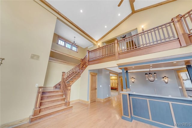 148 Mullen St, Tonawanda-City, NY 14150 - unfurnished living room featuring a chandelier, high vaulted ceiling, stairs, wood finished floors, and recessed lighting