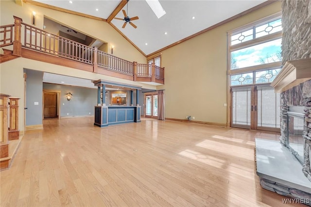 148 Mullen St, Tonawanda-City, NY 14150 - unfurnished living room with high vaulted ceiling, a stone fireplace, a ceiling fan, wood finished floors, and baseboards