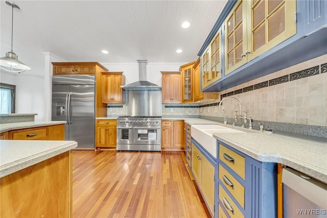 148 Mullen St, Tonawanda-City, NY 14150 - kitchen with high end appliances, wall chimney range hood, light countertops, decorative light fixtures, and brown cabinets