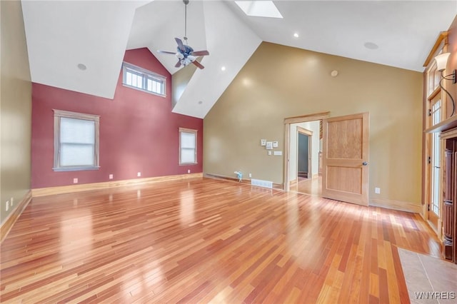 148 Mullen St, Tonawanda-City, NY 14150 - unfurnished living room featuring high vaulted ceiling, a skylight, a ceiling fan, light wood-style flooring, and baseboards