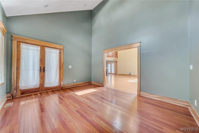 148 Mullen St, Tonawanda-City, NY 14150 - empty room featuring hardwood / wood-style floors, french doors, high vaulted ceiling, and baseboards