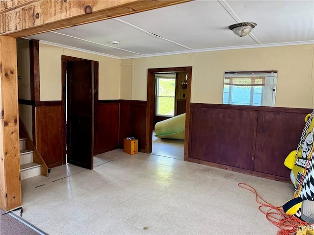 177 E Lake Rd, Deruyter, NY 13052 - unfurnished room featuring wainscoting, healthy amount of natural light, tile patterned floors, ornamental molding, and stairs