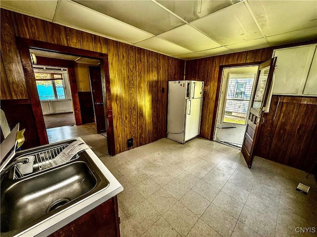 177 E Lake Rd, Deruyter, NY 13052 - kitchen featuring freestanding refrigerator, wood walls, and a sink