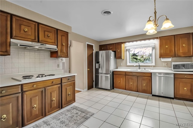 129 Summerview Rd, Amherst, NY 14221 - kitchen featuring stainless steel appliances, under cabinet range hood, brown cabinetry, a chandelier, and light countertops