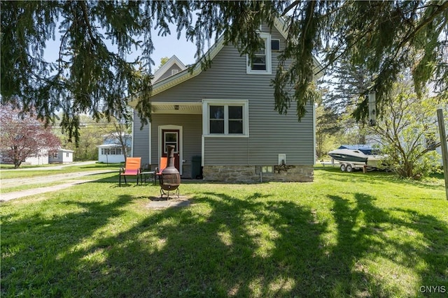 rear view of house featuring a yard