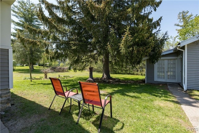 view of grassy yard featuring french doors