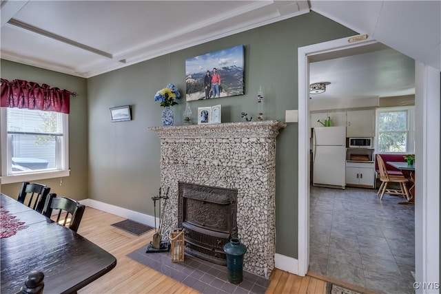 living area featuring crown molding, wood finished floors, and baseboards