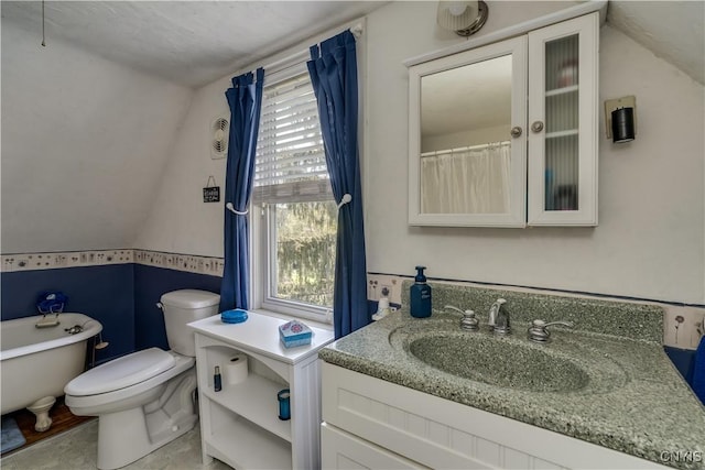 bathroom featuring vaulted ceiling, toilet, and vanity