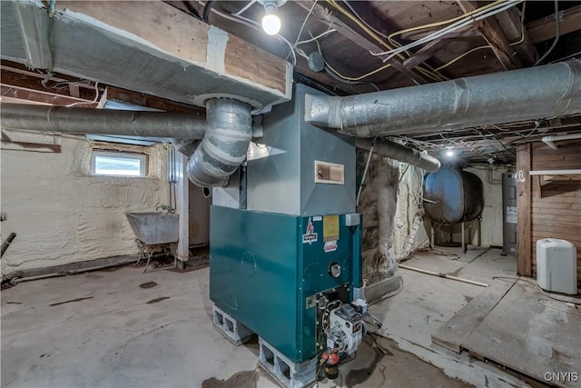 utility room featuring water heater, heating unit, and heating fuel